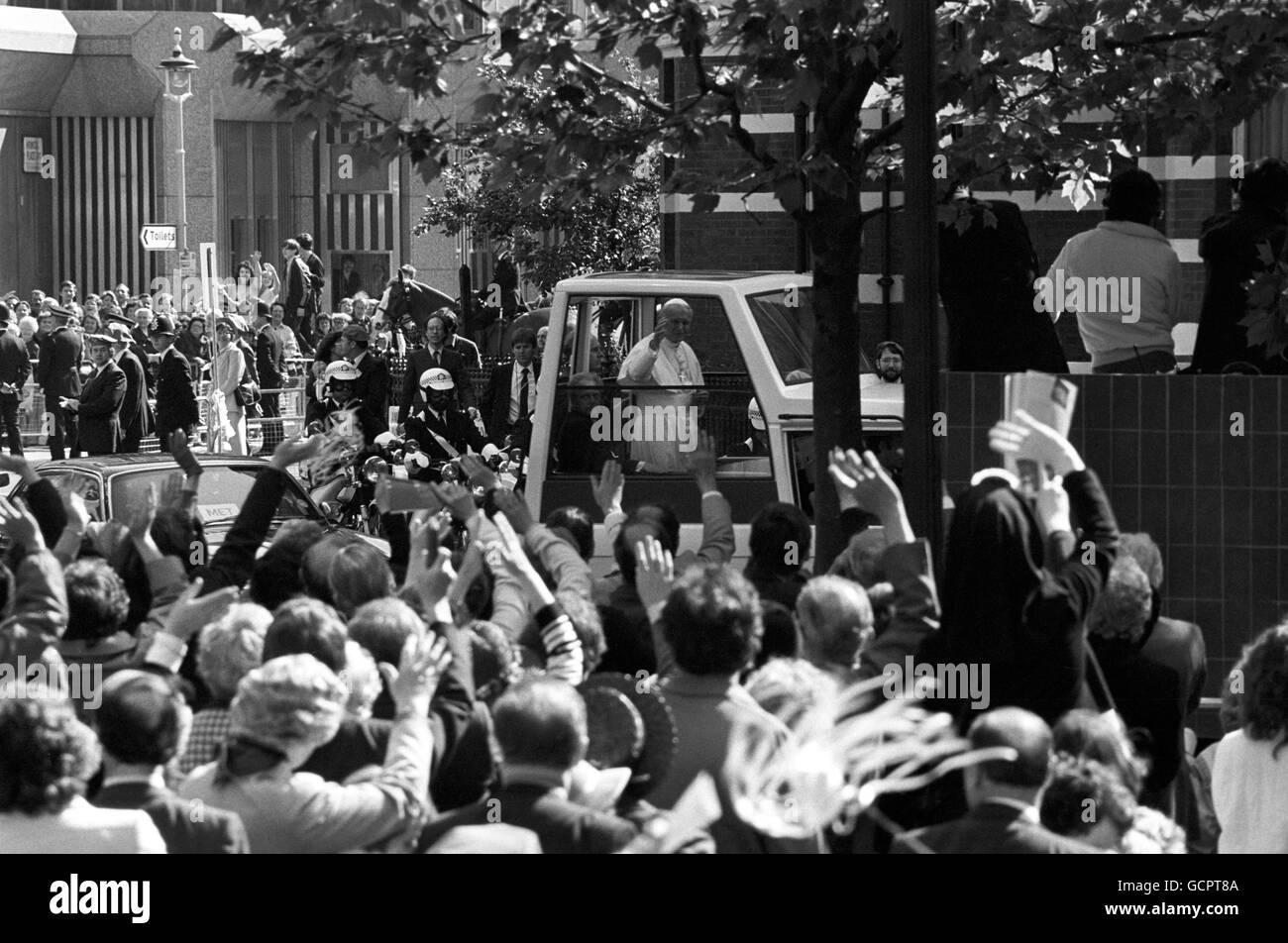 Le pape Jean-Paul II passe de son « Popemobile » à la foule accueillante qui borde les rues en route vers la cathédrale de Westminster. Banque D'Images