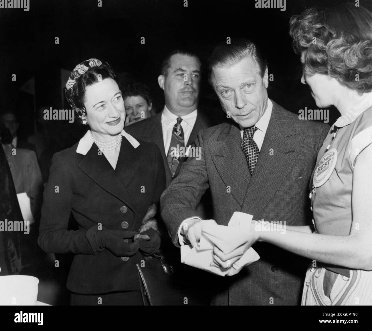 Le duc de Windsor, observé par la duchesse (encore l'une des femmes les  plus habillées au monde), prend un billet pour une bonne chance au  Waldorf-Astoria Hotel, New York, où ils ont