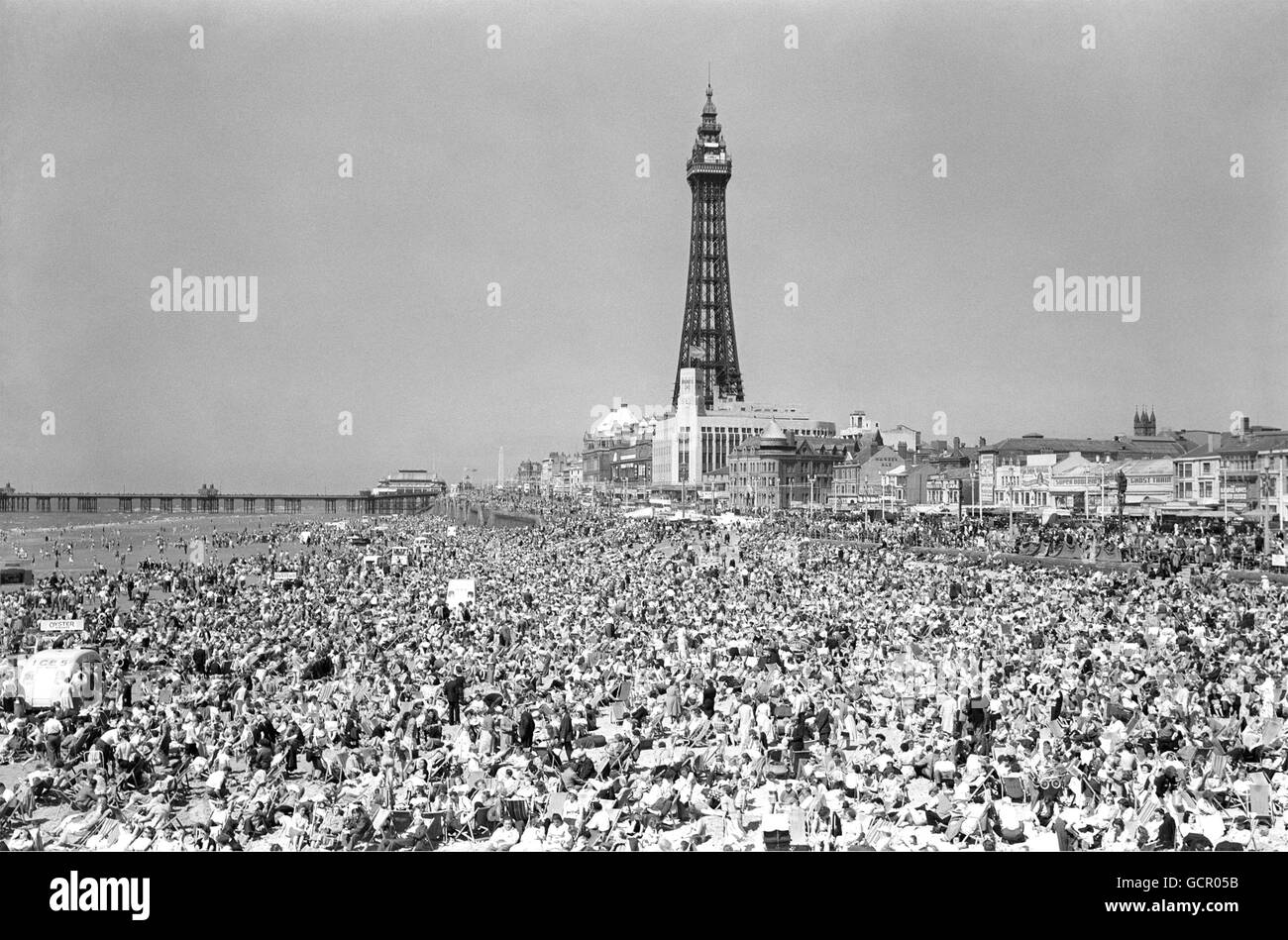 Rien ne pousse plus vite au soleil qu'une foule de vacances - il suffit de regarder cette plage entre les deux jetées à Blackpool. Cette semaine, le beau temps d'été les a vraiment fait sortir et il n'y a pas assez de place pour un autre soleil. 8 juillet 1955 Banque D'Images