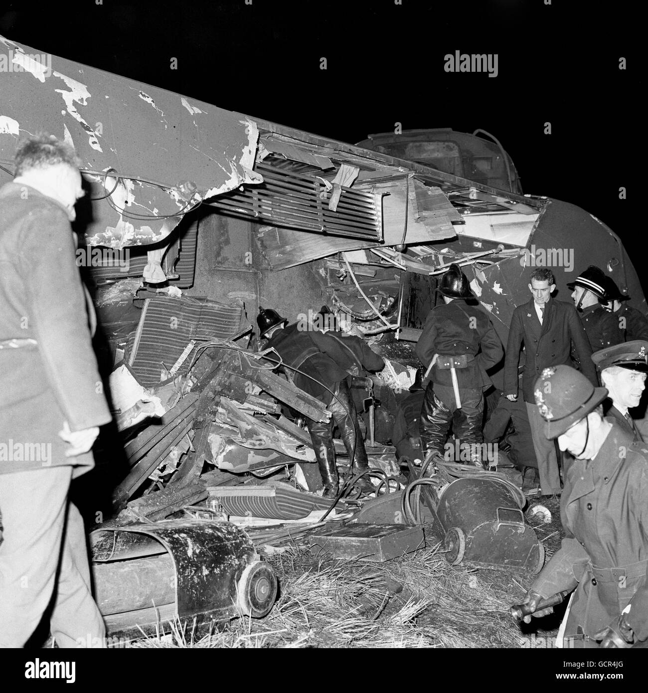 Les secouristes tentent d'atteindre les victimes piégées par un trou béant sur le toit d'un autocar allongé sur les côtés après l'accident du train à la mousse Green, Londres. Banque D'Images