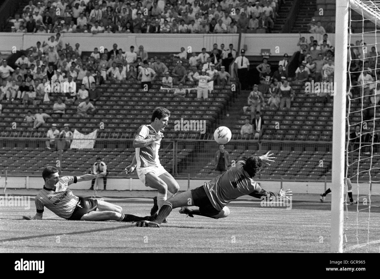 Clive Boxall (au centre) de Kidderminster Harriers ne parvient pas à marquer le but gagnant dans les minutes de clôture de la finale du Trophée du défi à Wembley.Le ballon a atteint la barre transversale surveillée par Steve Essex (à gauche) de Burton Albion et le gardien de plongée Martin New. Banque D'Images