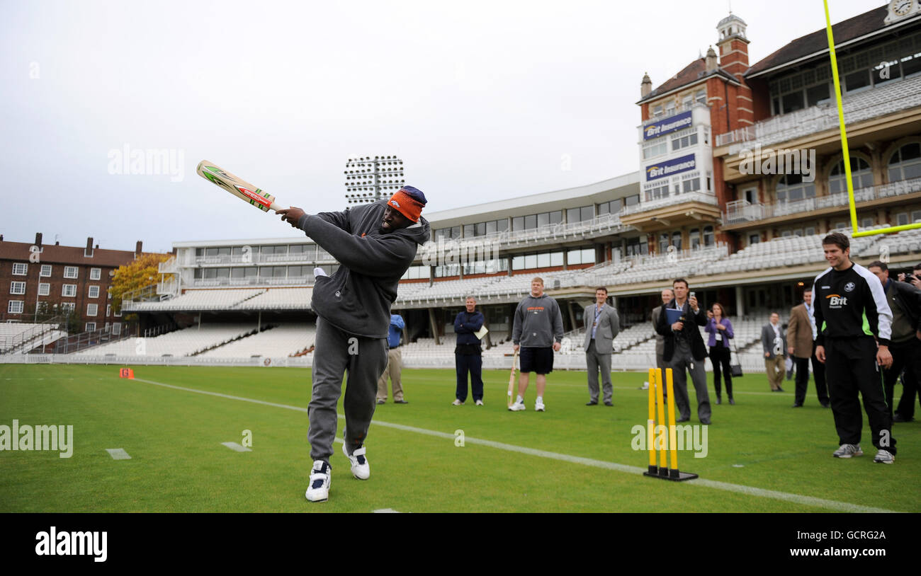 Daniel Graham de Denver Broncos essaie sa main au cricket. Regardé par Tom Lancefield de Surrey (à droite). Banque D'Images