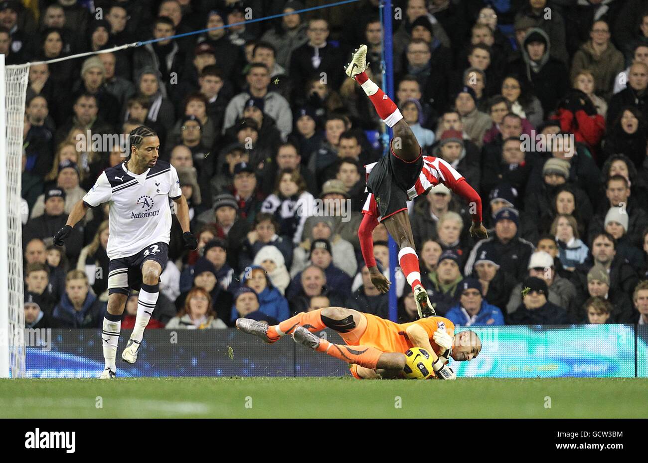 Danny Welbeck de Sunderland (en haut) dépasse le gardien de but Heurelho de Tottenham Hotspur Gomes (plancher) comme le regarde Benoit Assou-Ekotto (gauche) de Tottenham Hotspur Banque D'Images