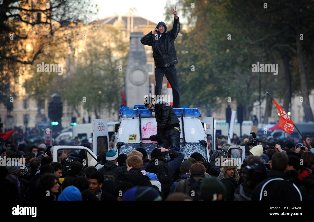 Un manifestant lors d'une marche étudiante contre des coupures dans l'éducation du gouvernement se tient sur une fourgonnette de police qui a été entourée par des manifestants à Londres. Banque D'Images