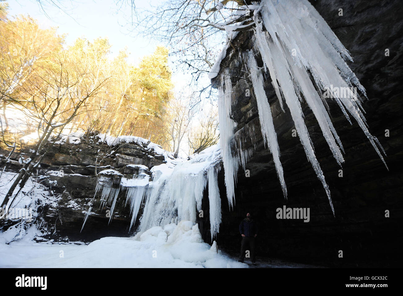 Un homme regarde les glaces de la grotte de Gibsons à Bowles, Teesdale, alors que les conditions météorologiques hivernales continuent d'attraper le Royaume-Uni. Banque D'Images