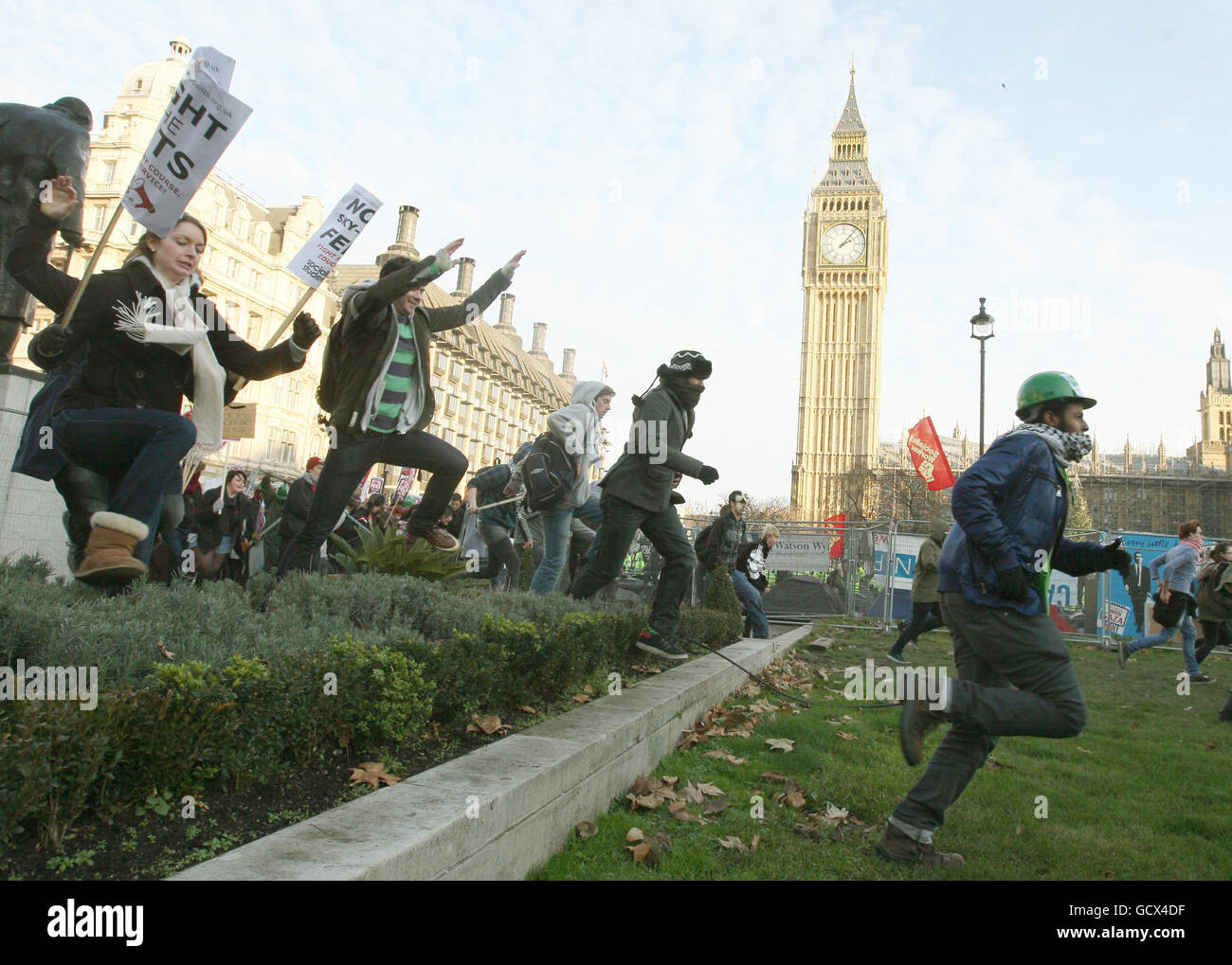 Des manifestants se sont frainés un tour sur la place du Parlement après avoir abaissé les barrières, comme les étudiants le démontrent à Westminster, à Londres, contre les augmentations prévues des frais de scolarité. Banque D'Images