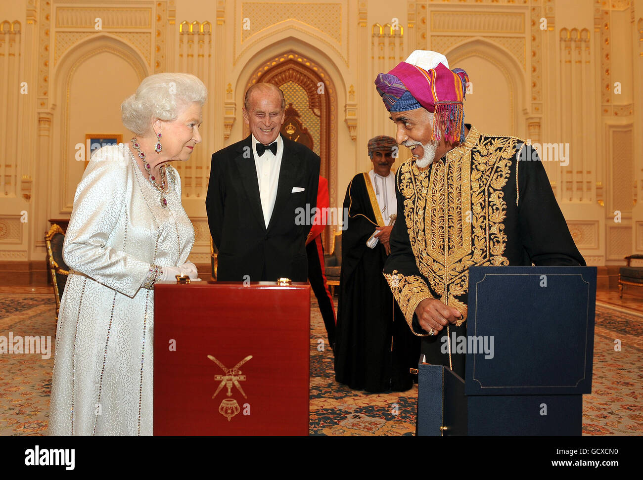 La reine Elizabeth II attend avec anticipation devant le sultan d'Oman, sa Majesté le sultan Qaboos bin Said lui présente un oeuf de style Faberge musical d'or, avant un banquet d'État à son palais à Muscat, Oman. Banque D'Images