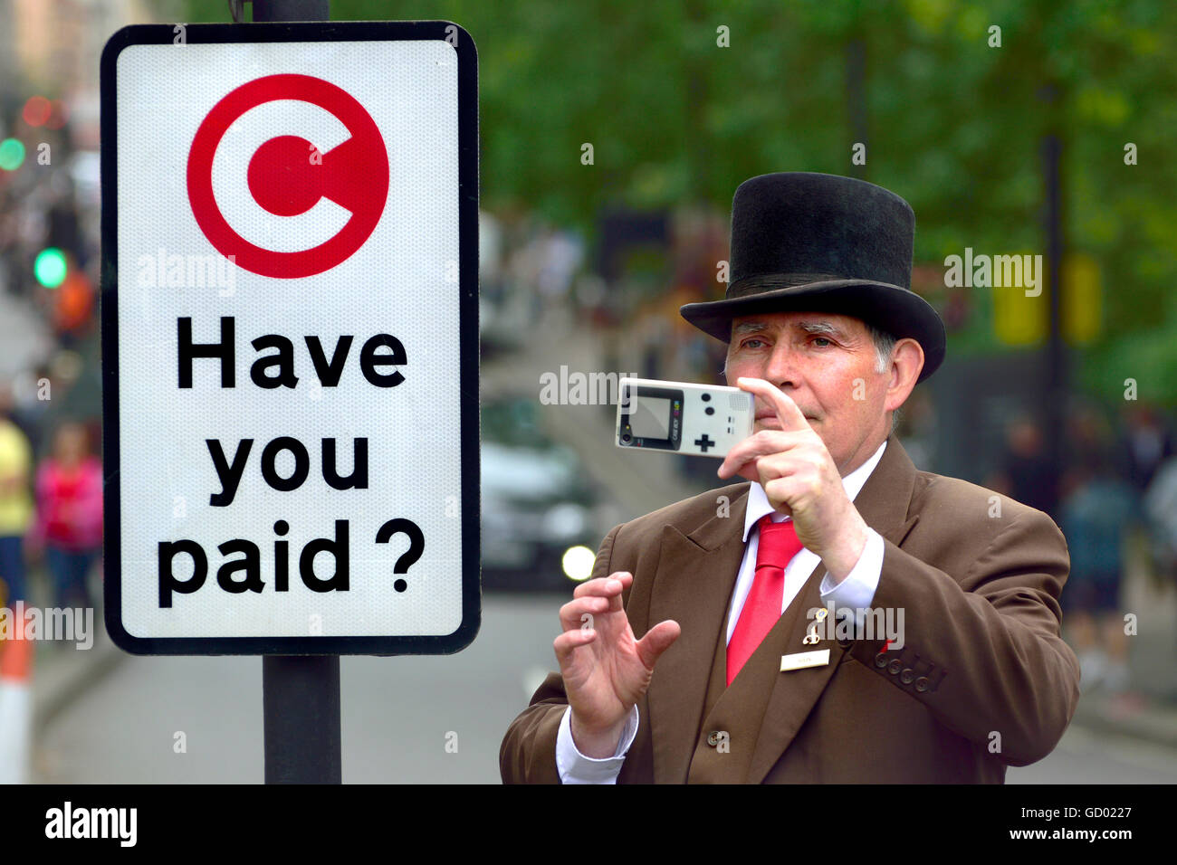 Londres, Angleterre, Royaume-Uni. Portier de l'hôtel prendre une photo d'une manifestation à Park Lane, à côté d'une Congestion Charge sign Banque D'Images Londres, Angleterre, Royaume-Uni. Portier de l'hôtel prendre une photo d'une manifestation à Park Lane, à côté d'une Congestion Charge sign Banque D'Images