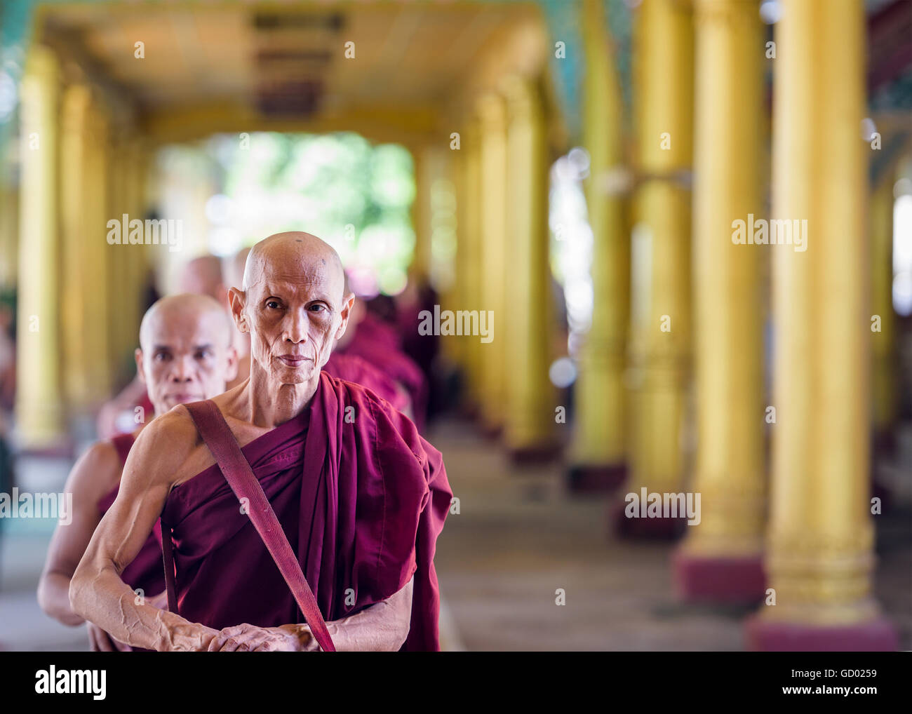 BAGO, MYANMAR - 19 octobre 2015 : ligne de moines jusqu'à recevoir des offrandes de nourriture à l'heure du déjeuner à Kyaly Wai Khat monastère. Banque D'Images