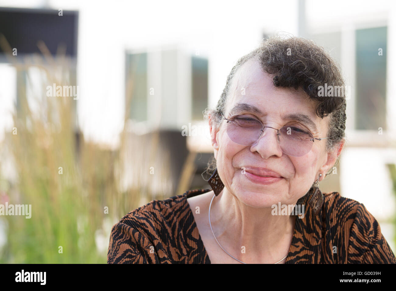 Closeup portrait portrait, grand-mère avec des lunettes, smiling, fond plein air isolé Banque D'Images