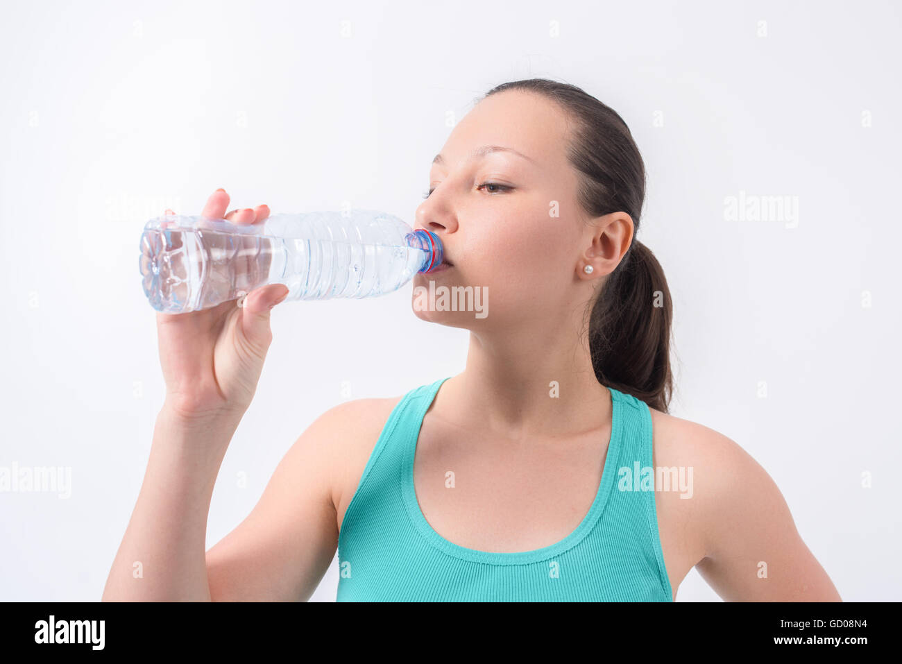 Femme l'eau potable de la bouteille sur un fond isolé blanc Banque D'Images