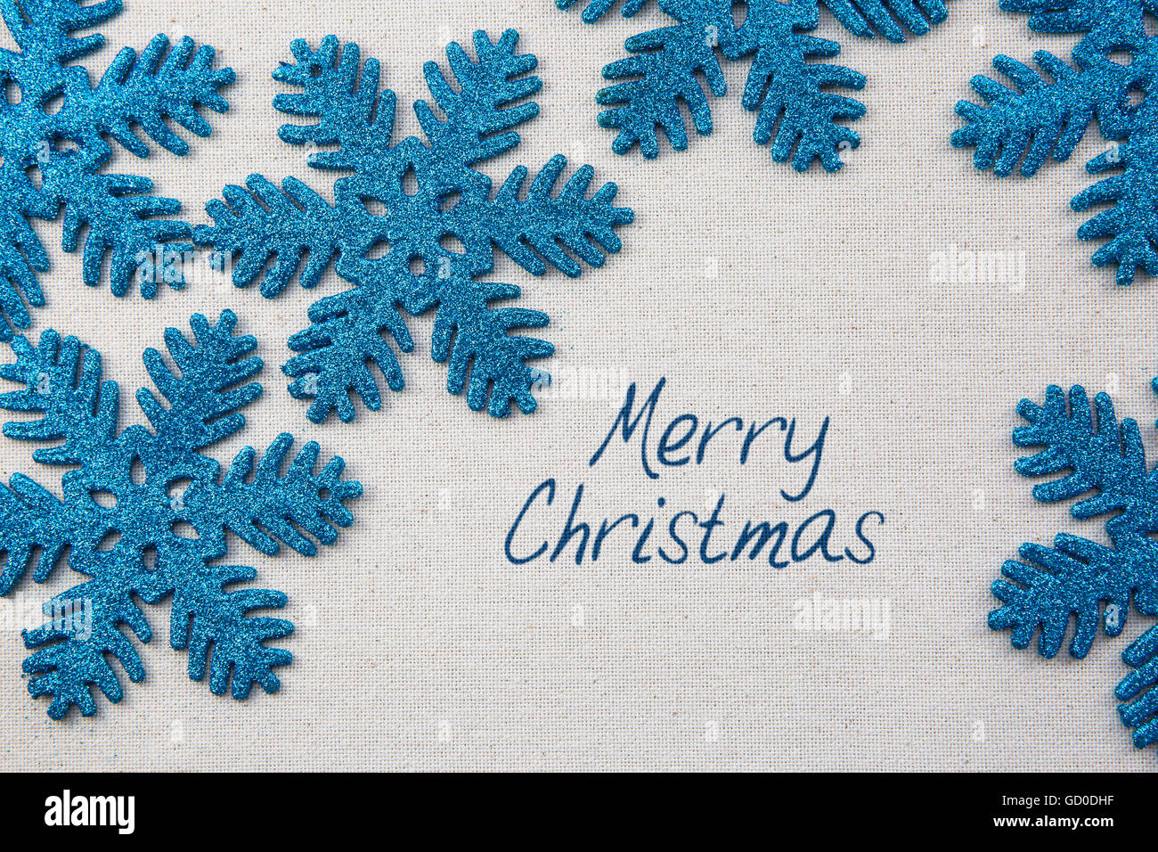 Sparkling blue snowflake ornements sur , avec surface d'accueil joyeux Noël. Banque D'Images