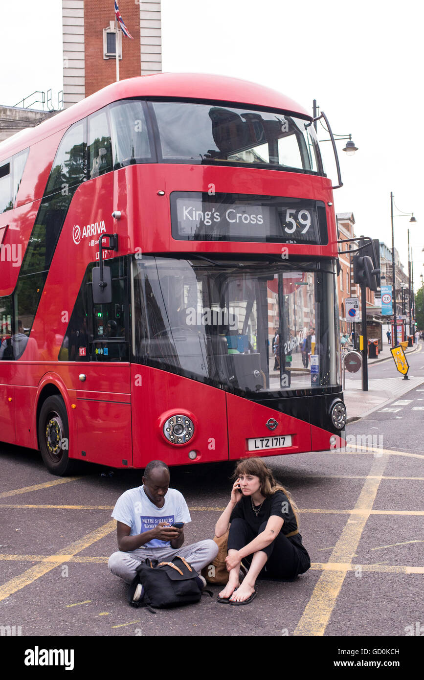 Brixton, Londres, Royaume-Uni. 9 juillet 2016. Jeunes manifestants de bloquer un bus sur Brixton high street. Des centaines de vies noir Question partisans ont marché sur le poste de police local avant qu'un sit-in de protestation sur Brixton High Street qui a rues de Londres à l'arrêt. La marche est en réponse à la fusillade mortelle de Philando Castille au Minnesota et Alton Sterling en Louisiane. Credit : Nicola Ferrari/Alamy Live News. Banque D'Images