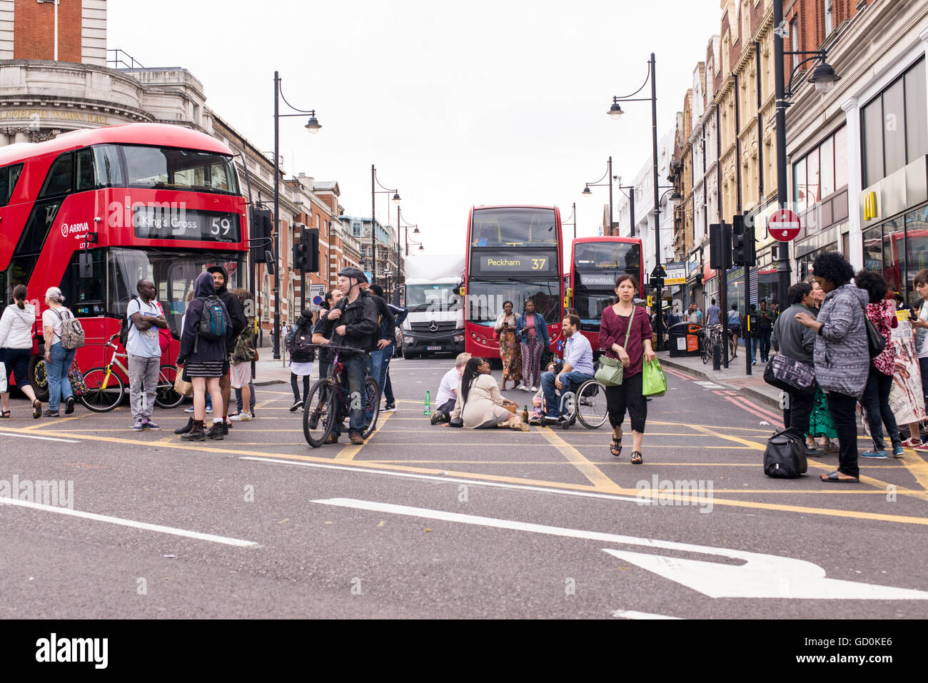 Brixton, Londres, Royaume-Uni. 9 juillet 2016. Jeunes manifestants de bloquer un bus sur Brixton high street. Des centaines de vies noir Question partisans ont marché sur le poste de police local avant qu'un sit-in de protestation sur Brixton High Street qui a rues de Londres à l'arrêt. La marche est en réponse à la fusillade mortelle de Philando Castille au Minnesota et Alton Sterling en Louisiane. Credit : Nicola Ferrari/Alamy Live News. Banque D'Images