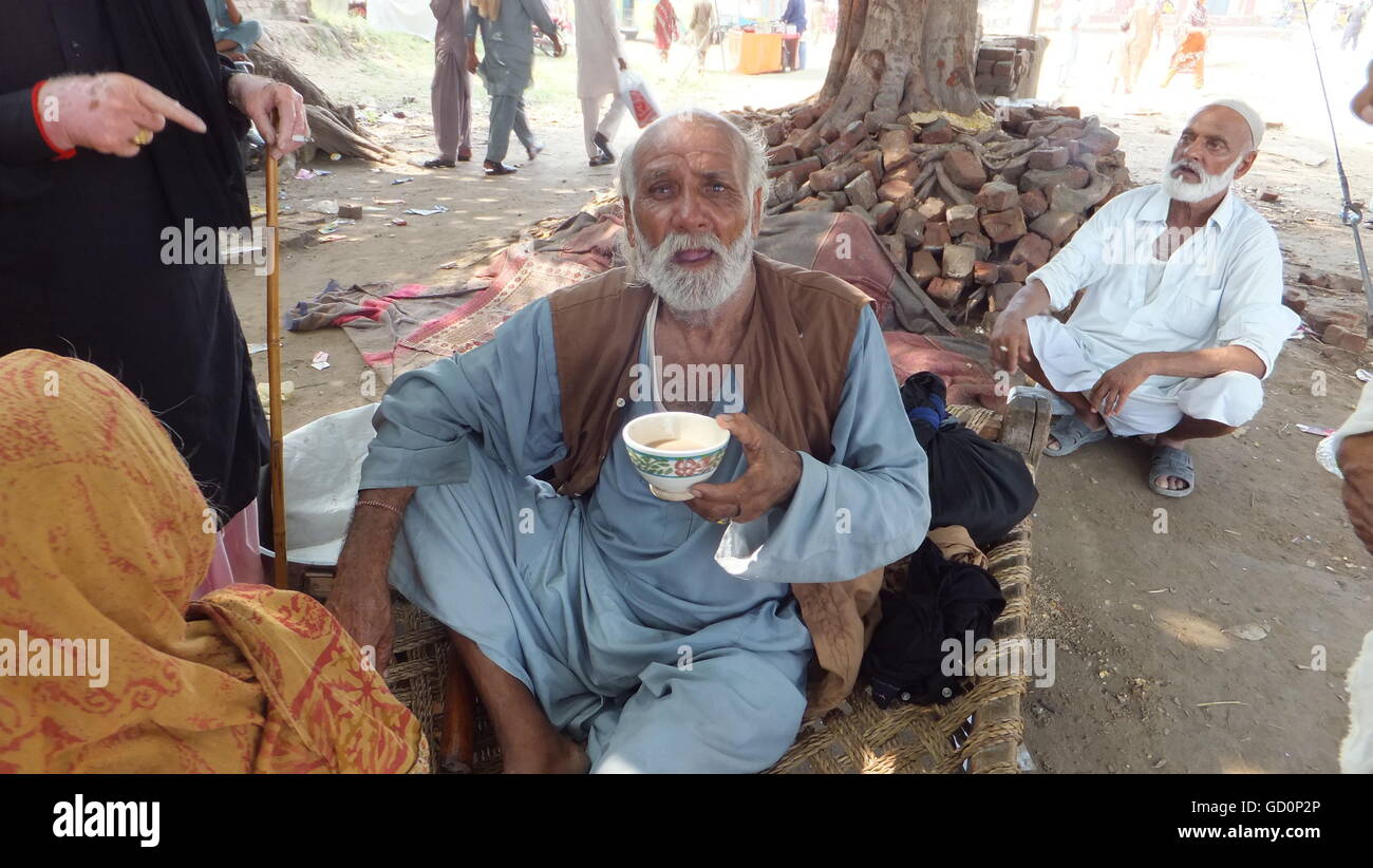 Un vieil homme est bénéficiant d'un plateau à l'occasion du 456e anniversaire de l'Urse () du célèbre saint Hazrat Shah dans Diryai Bhattian Behlole Pindi ville du Punjab au Pakistan. Banque D'Images