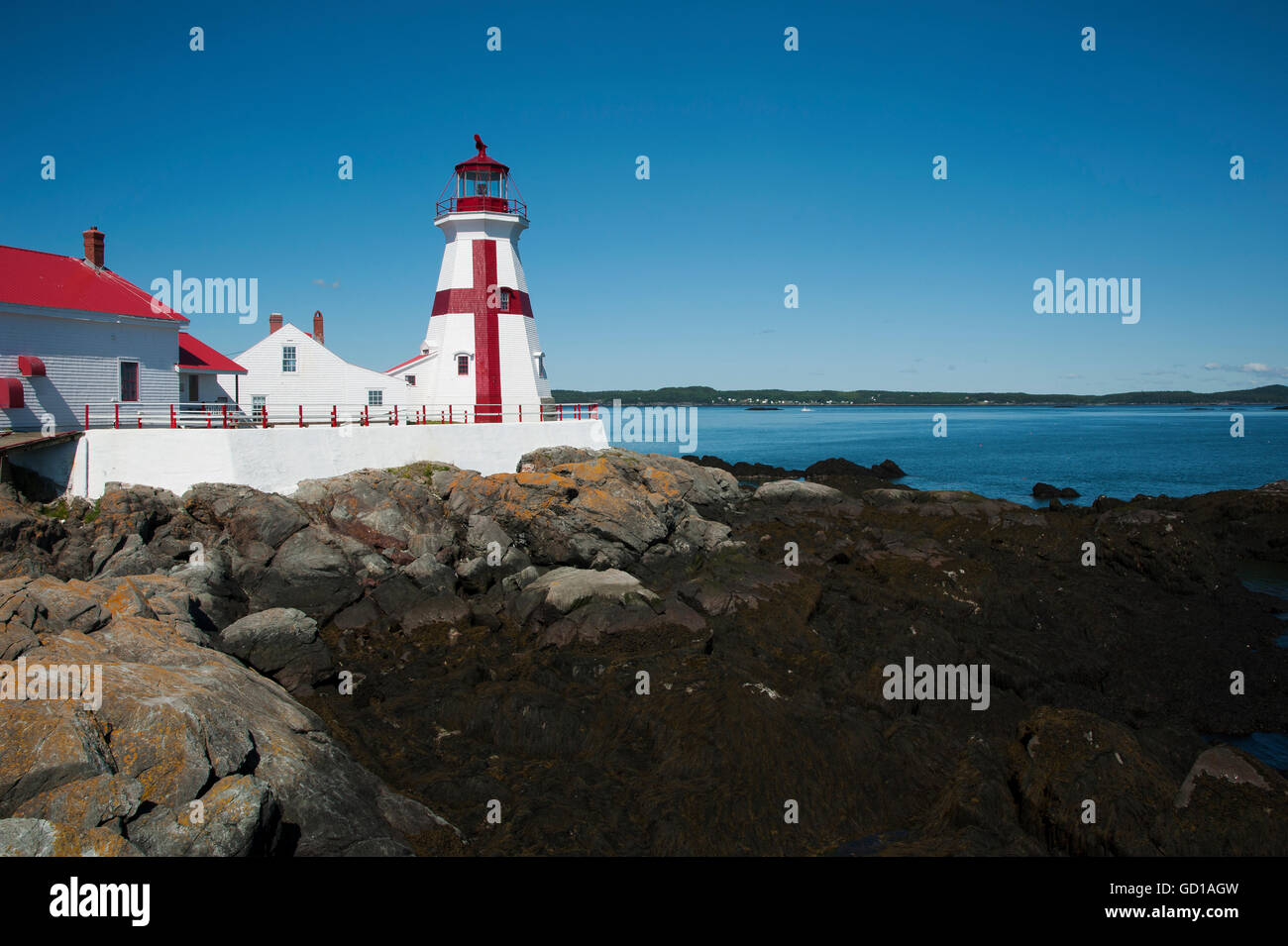 Harbour Head Lighthouse à marée basse sur une paisible journée d'été. Il est célèbre pour avoir peint une croix pour les marins à voir de longues distances. Banque D'Images