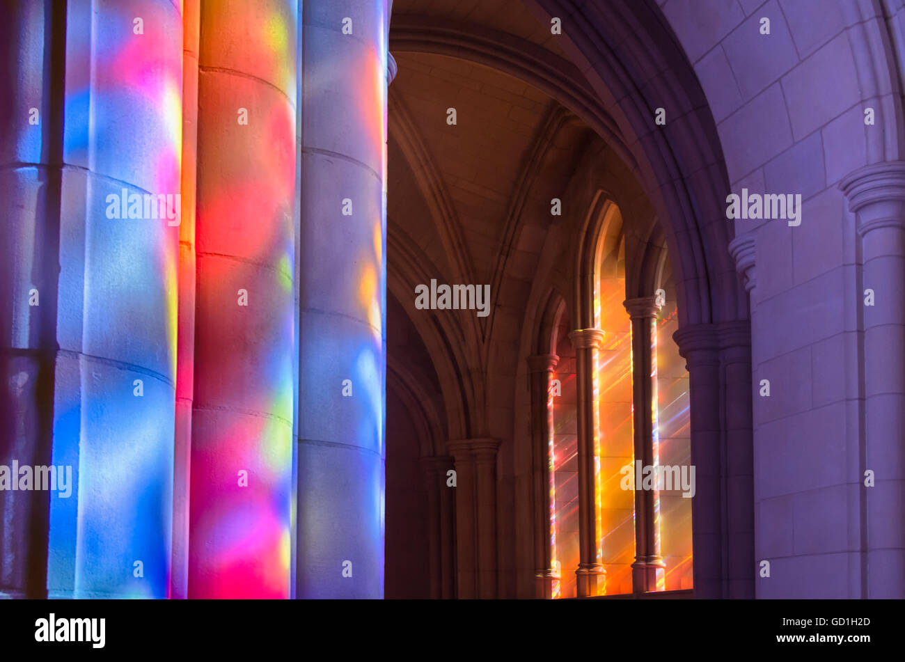 Streaming de la lumière à travers les vitraux colorés avec des colonnes d'éclairage le long de la nef de la cathédrale Banque D'Images