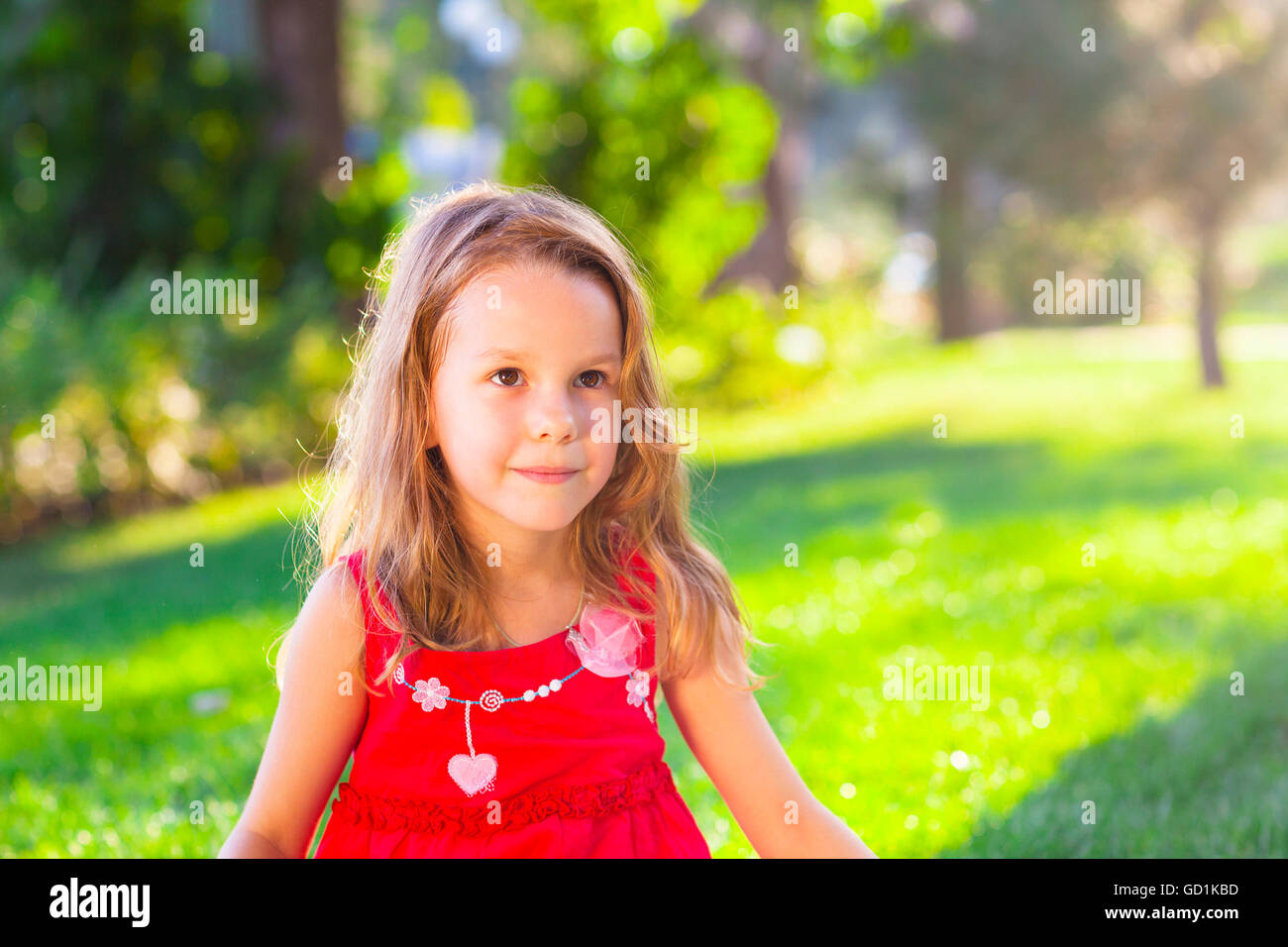 Portrait d'une drôle de petite fille dans le parc d'été Banque D'Images