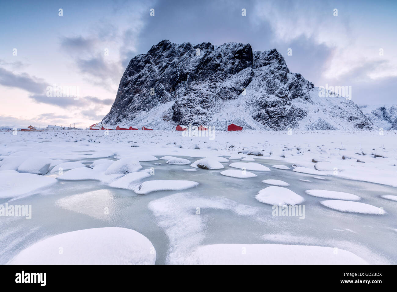 Des sommets enneigés et des maisons de pêcheurs typiques de la trame appelé Rorbu, Eggum, Île Vestvagoy, îles Lofoten, Norvège Banque D'Images