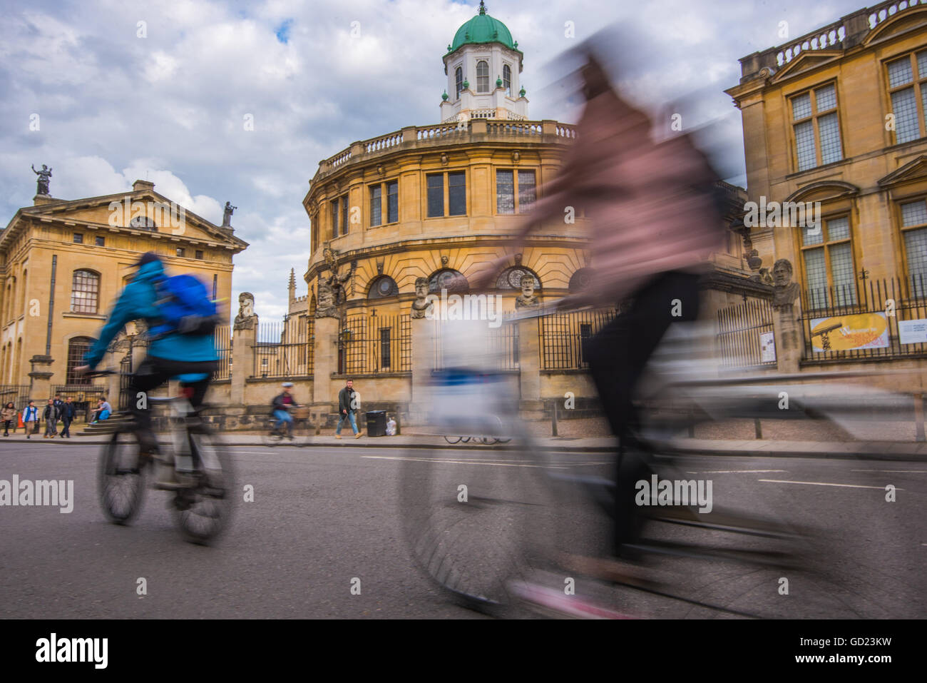 Les cyclistes passant le Sheldonian Theatre, Oxford, Oxfordshire, Angleterre, Royaume-Uni, Europe Banque D'Images