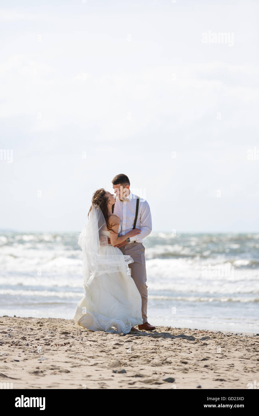 Happy wedding couple hugging sur la plage à l'heure d'été Banque D'Images