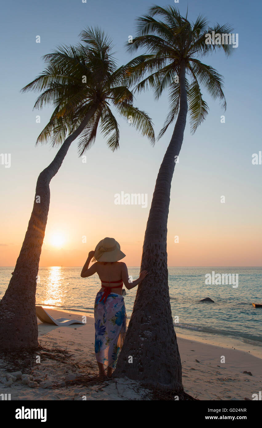 Femme sur la plage au coucher du soleil, l'île de Maafushi, Kaafu Atoll, Maldives, océan Indien, Asie Banque D'Images