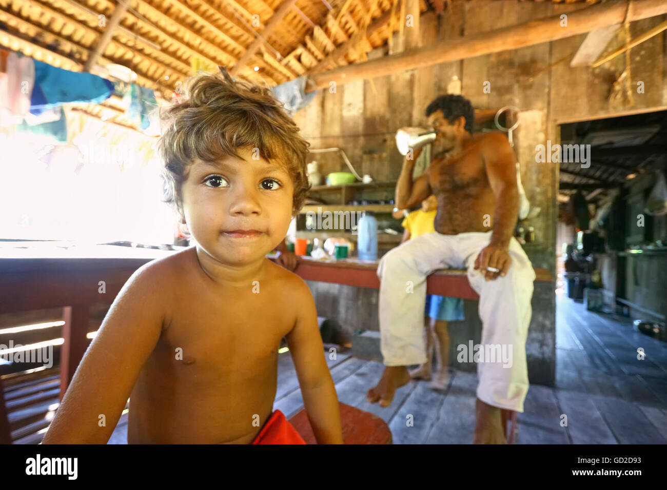 L'Amazonas, Brésil - le 14 août 2008 : Jeune garçon et son père dans une maison en bois, sur l'Amazone banque. Banque D'Images