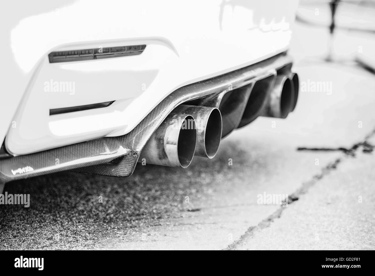 Double-tuyaux d'échappement d'une voiture de sport moderne, noir et blanc Banque D'Images