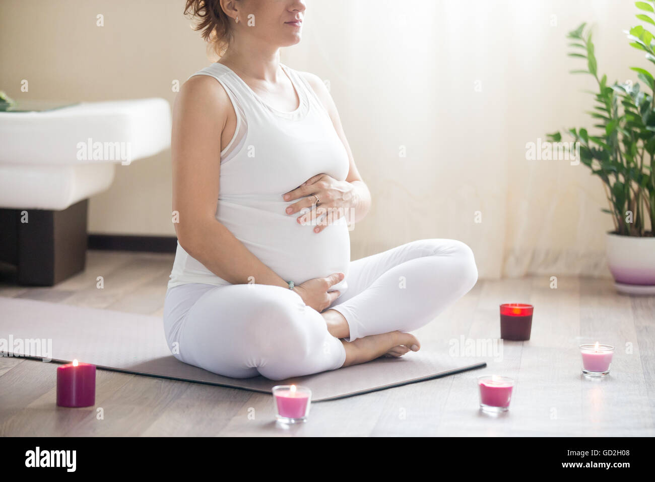 Grossesse en santé et de remise en forme de yoga. Les jeunes femmes enceintes yoga woman respirer tout en travaillant à l'intérieur de salon. Femmes enceintes Banque D'Images