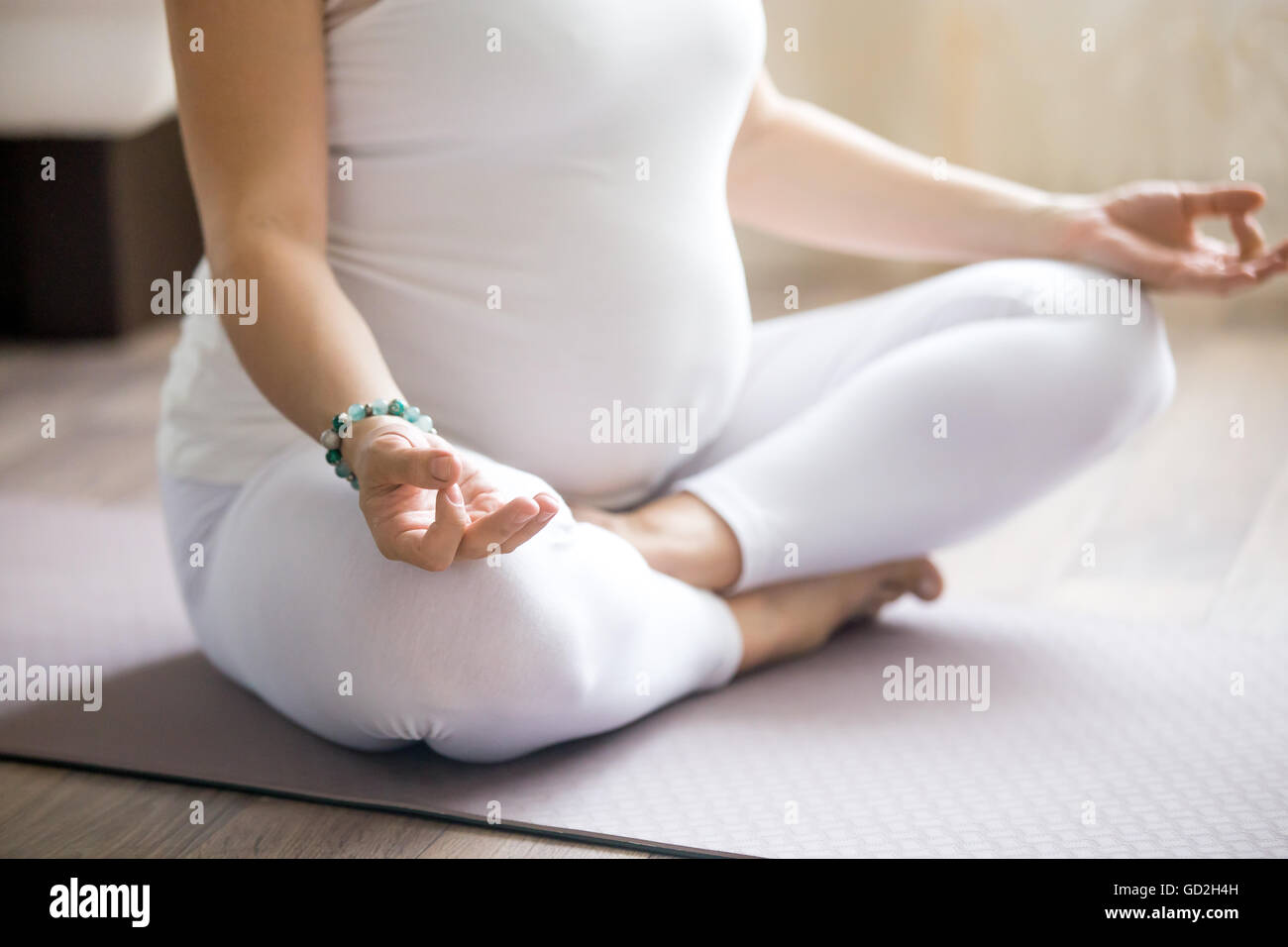 Grossesse en santé et de remise en forme de yoga. Les jeunes femmes enceintes yoga femme travaillant à l'intérieur de la classe. Modèle enceinte assis Banque D'Images