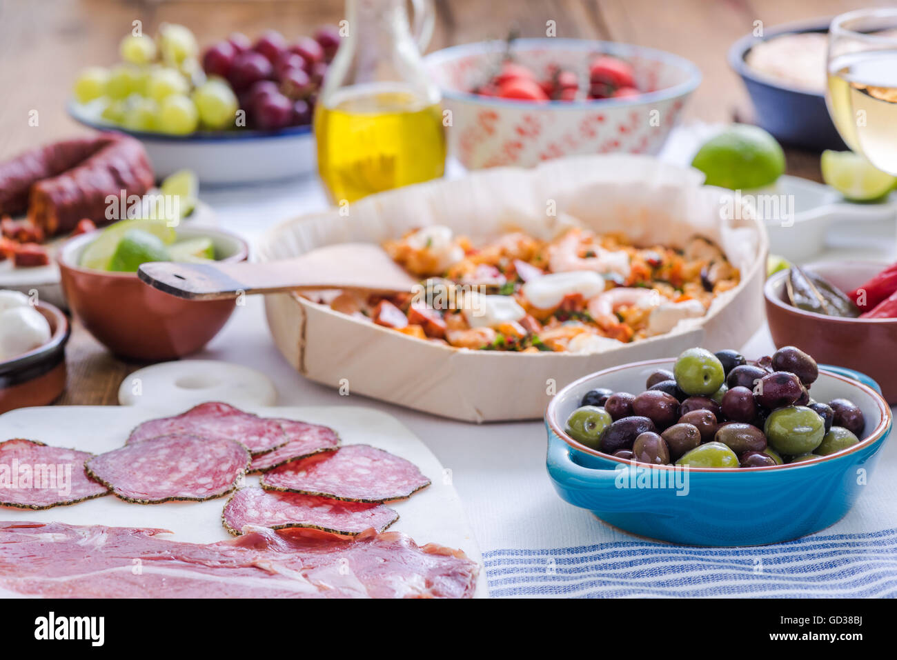 Olives fraîches et paella en arrière-plan, le partage de nourriture sur la table Banque D'Images