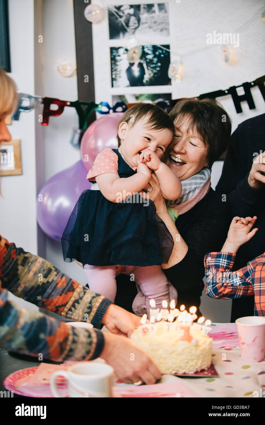 Une famille se sont réunis pour célébrer une fillette d'un an. Un gâteau avec plein de bougies. Banque D'Images