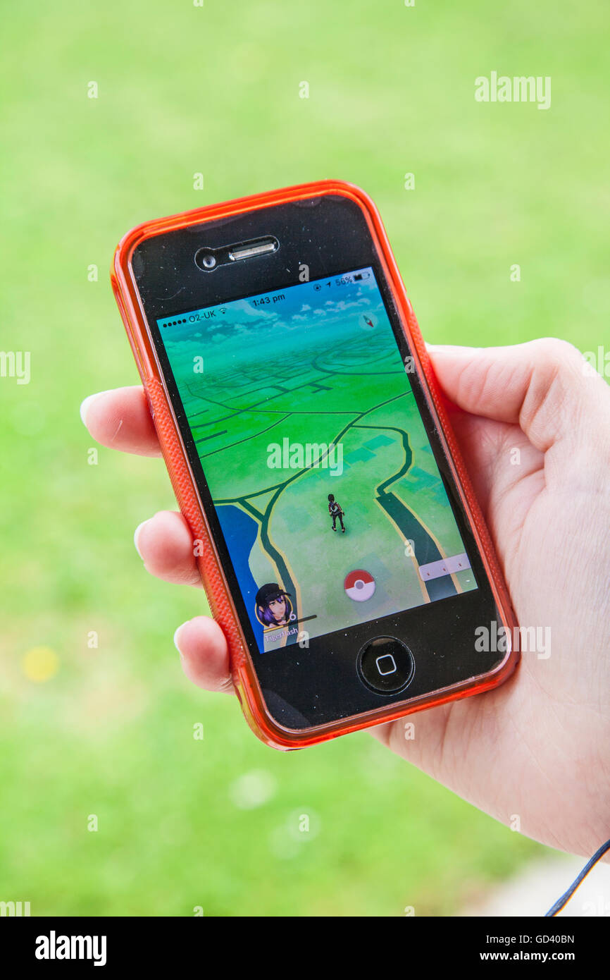 Une jeune personne utilise un iPhone pour jouer à Pokémon sur rendez-vous, le dernier jeu de réalité augmentée mobile app pour frapper le marché des applications dans le monde entier. Banque D'Images