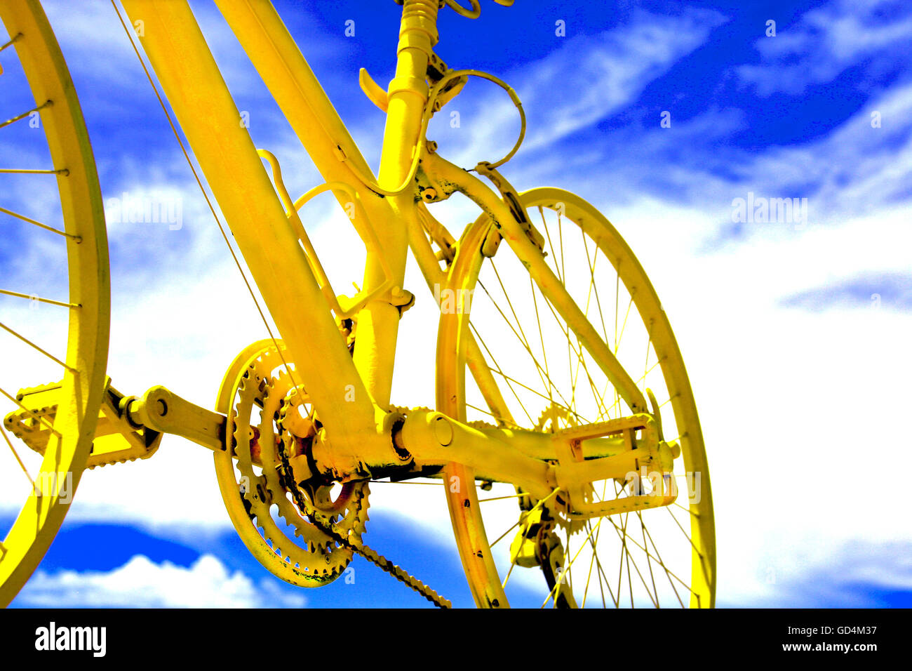 Vélo jaune vif dans le ciel Banque D'Images