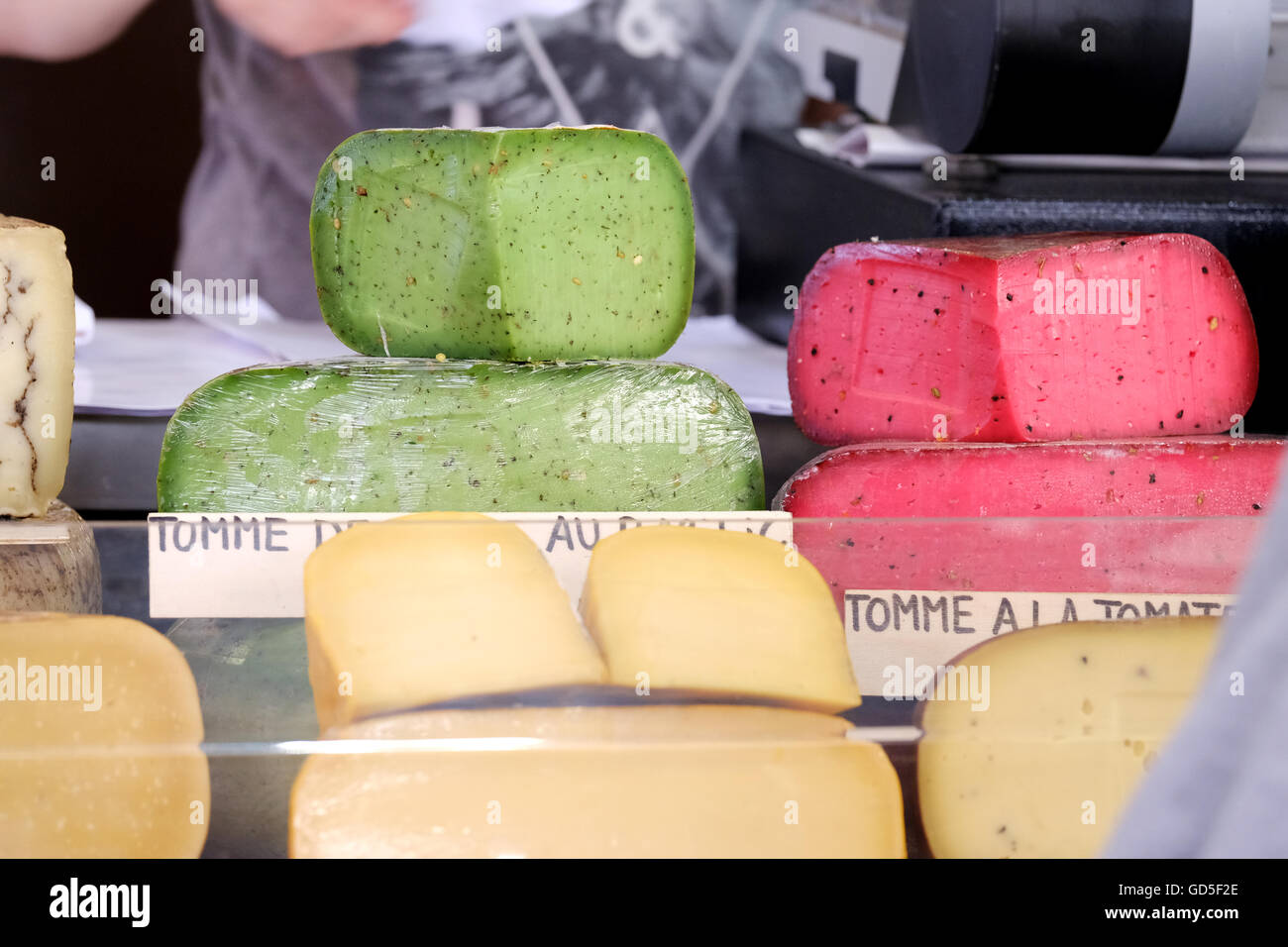 Rouge et vert aux couleurs vives les fromages frais en vente sur un étal du marché Banque D'Images