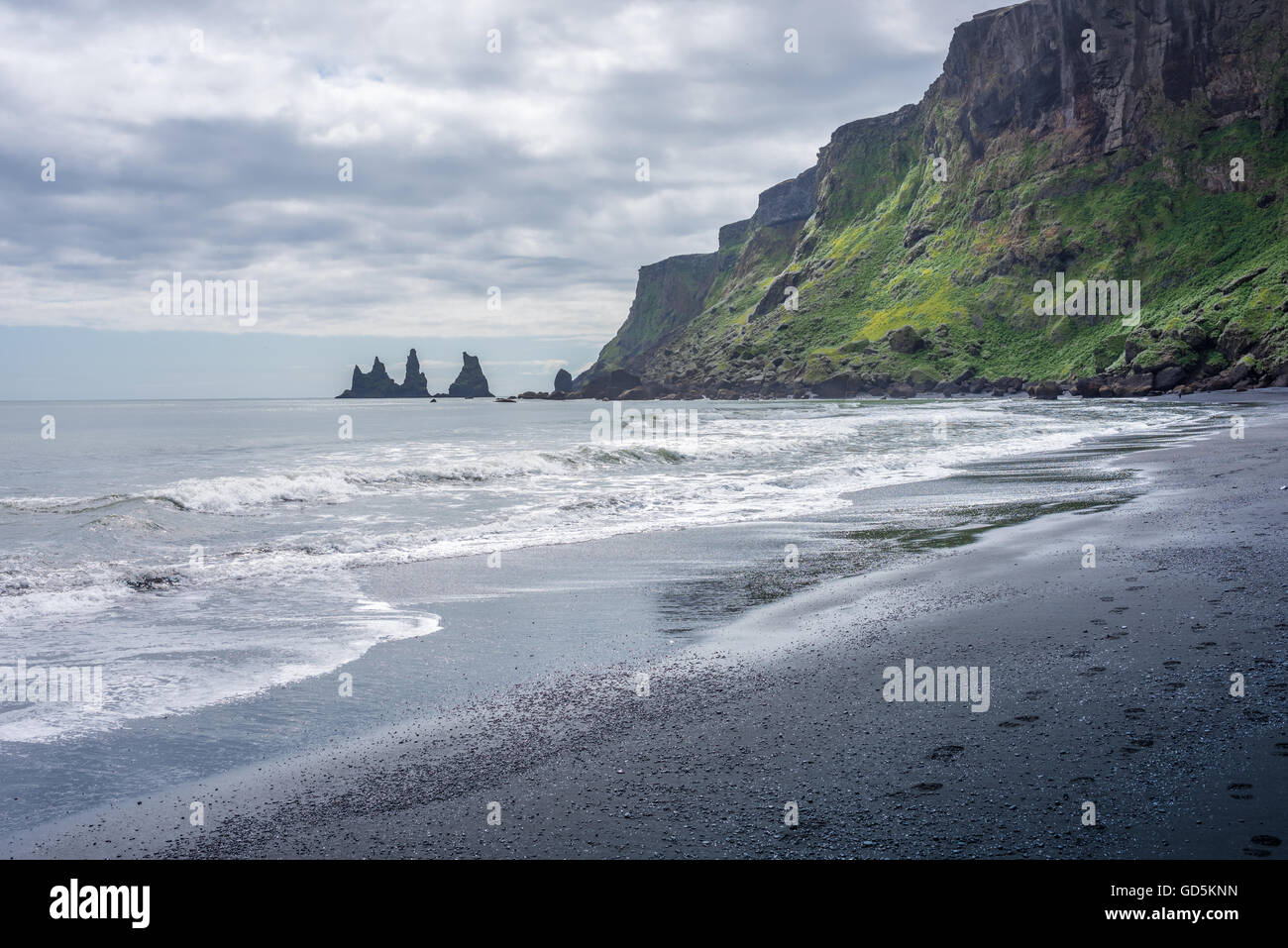 La plage noire avec l'Reynisfjara qui jouit basaltiques de Reynisdrangar en arrière-plan. Le sud de l'Islande Banque D'Images