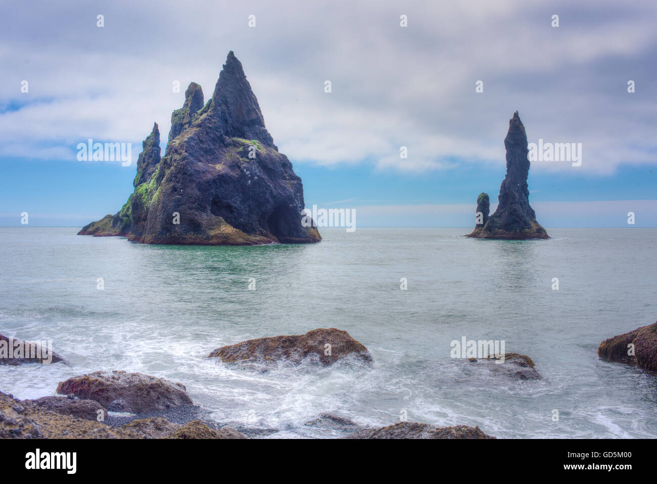 La plage noire avec l'Reynisfjara qui jouit basaltiques de Reynisdrangar en arrière-plan. Le sud de l'Islande Banque D'Images