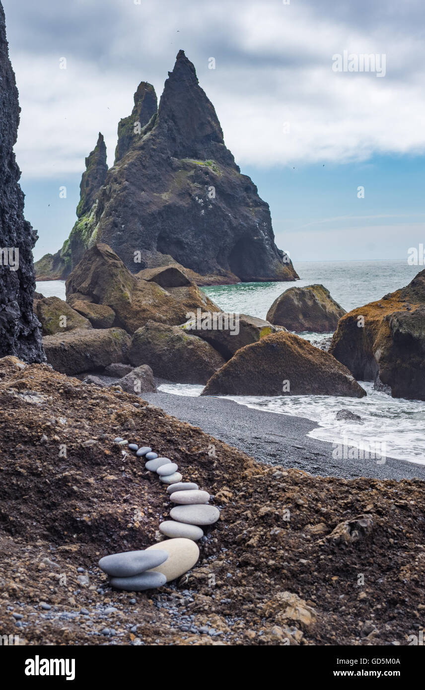 La plage noire avec l'Reynisfjara qui jouit basaltiques de Reynisdrangar en arrière-plan. Le sud de l'Islande Banque D'Images