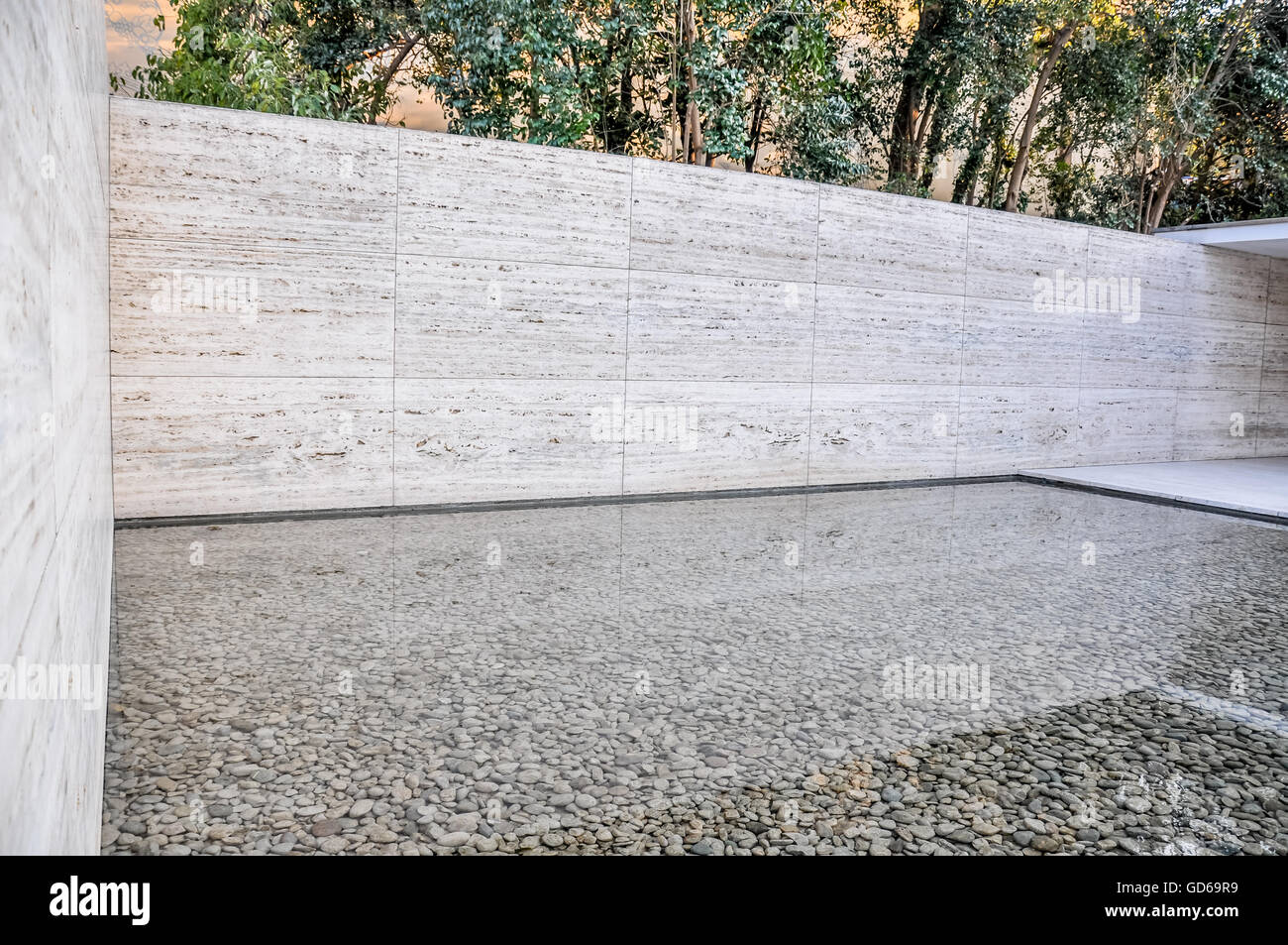 Eaux calmes dans un miroir d'eau entouré de murs en marbre et arbres au pavillon de Barcelone en Espagne Banque D'Images