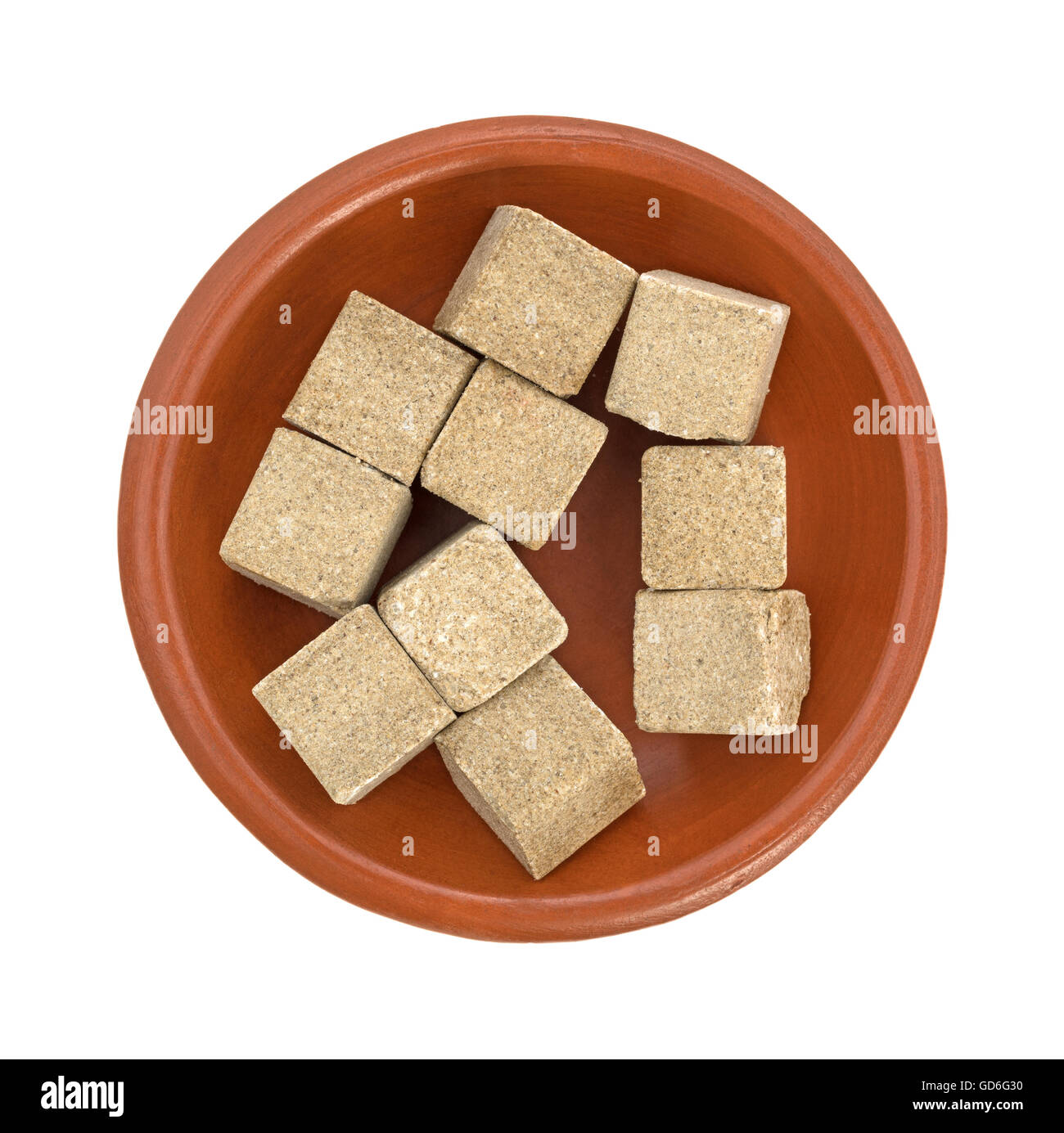 Vue de dessus de plusieurs cubes de bouillon de boeuf assaisonné de remplir un petit bol isolé sur un fond blanc. Banque D'Images