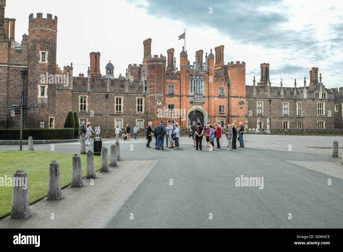 Les visiteurs d'attendre que la porte s'ouvre à l'entrée du palais royal à Hampton Court, London, England. Banque D'Images