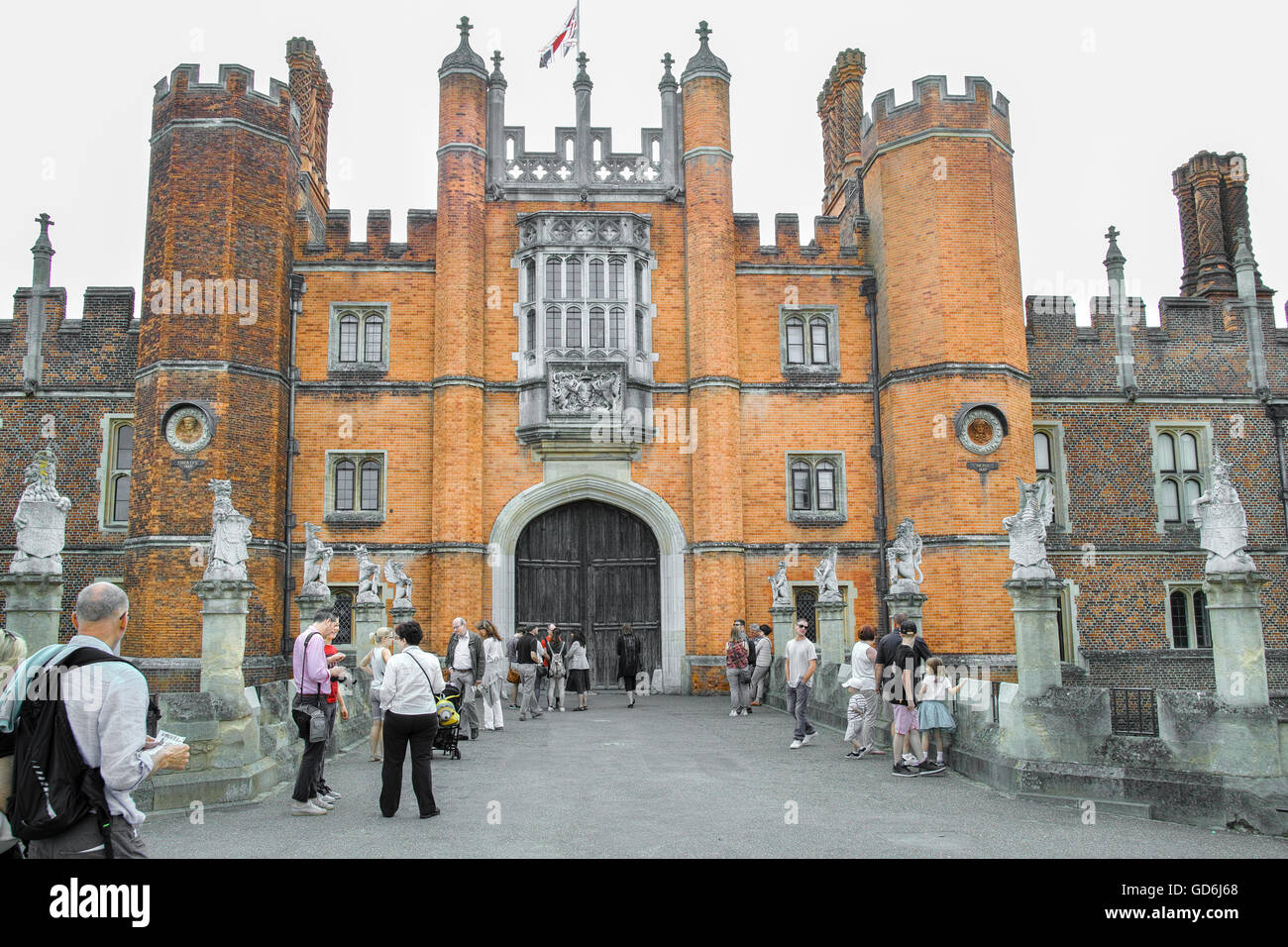 Les visiteurs d'attendre que la porte s'ouvre à l'entrée du palais royal à Hampton Court, London, England. Banque D'Images