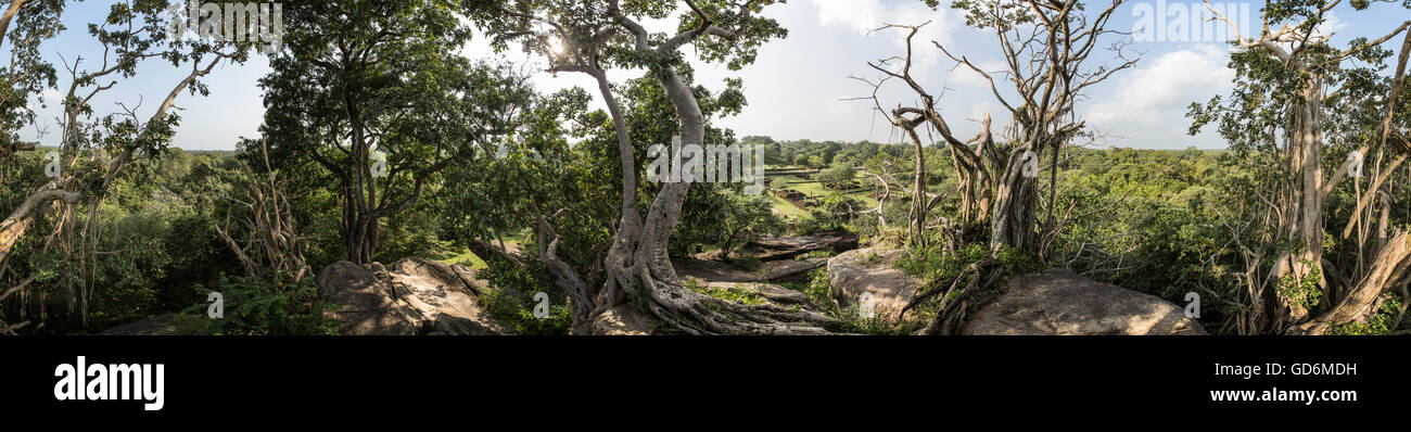 Tourné à partir du haut de Gopala Pabbatha, Polonnaruwa, Sri Lanka. Un petit monastère de la grotte recouvert d'arbres sur les rochers Banque D'Images