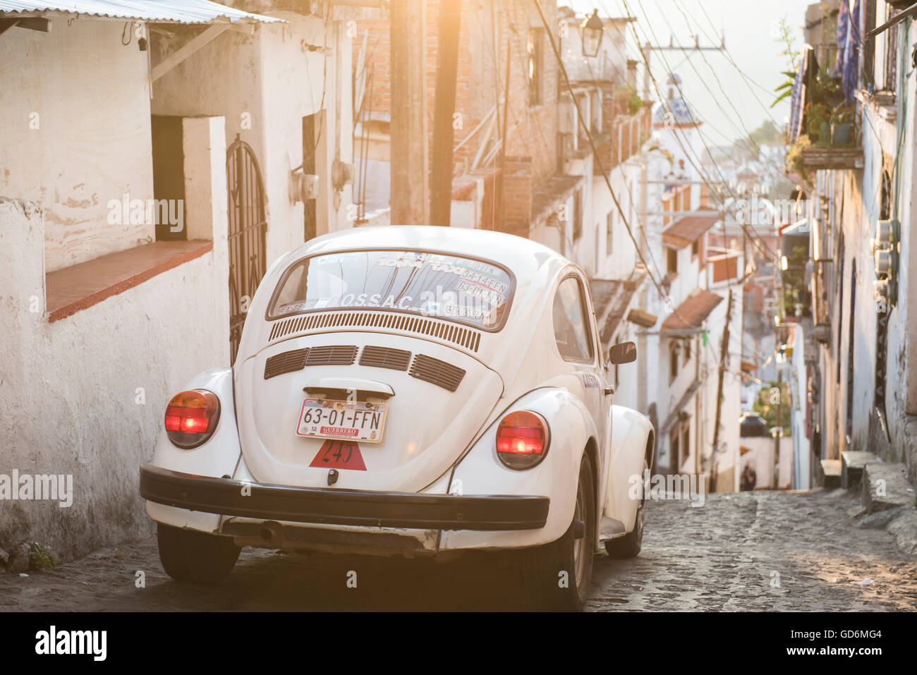 Un classique Volkswagen monte vers le bas d'une colline dans les rues pavées de Taxco, Guerrero, Mexique. Banque D'Images