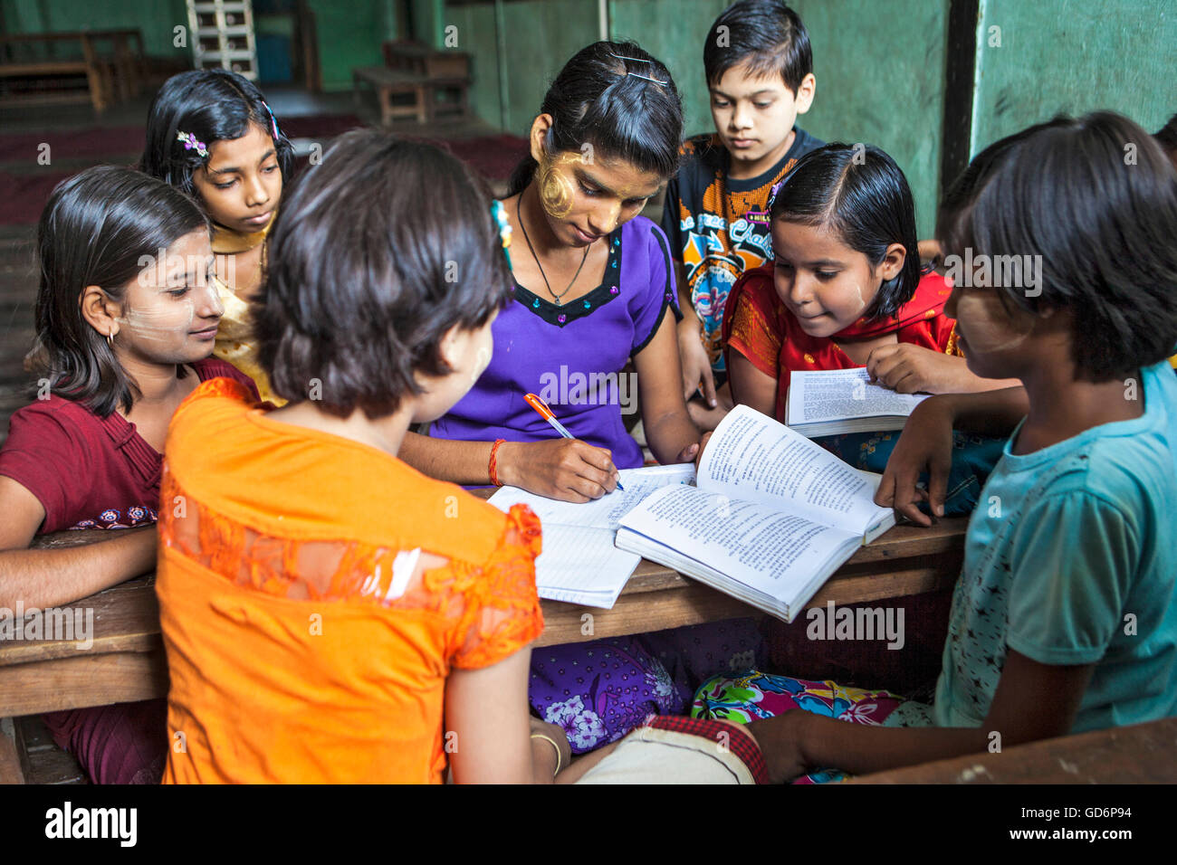 Professeur en classe la comparaison des notes pour les élèves de classe Hindi Arya Gurukul, Temple Arya Samaj, Zyd, qui a été créé en 20-02-2012. Jiwabari, Myanmar. Banque D'Images