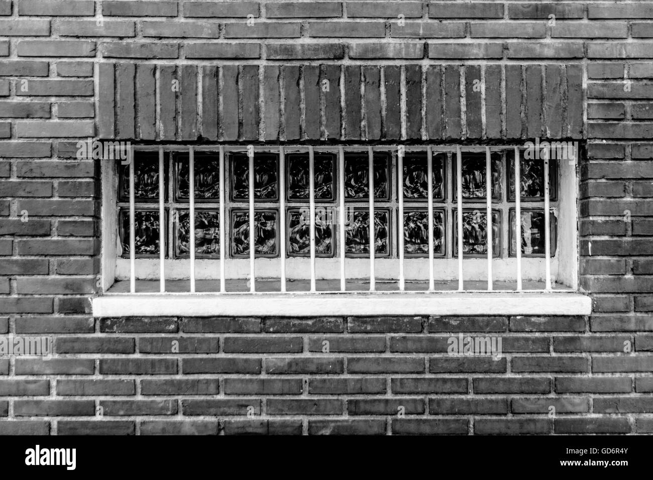 Portrait de la fenêtre avec des bars sur mur de brique Banque D'Images