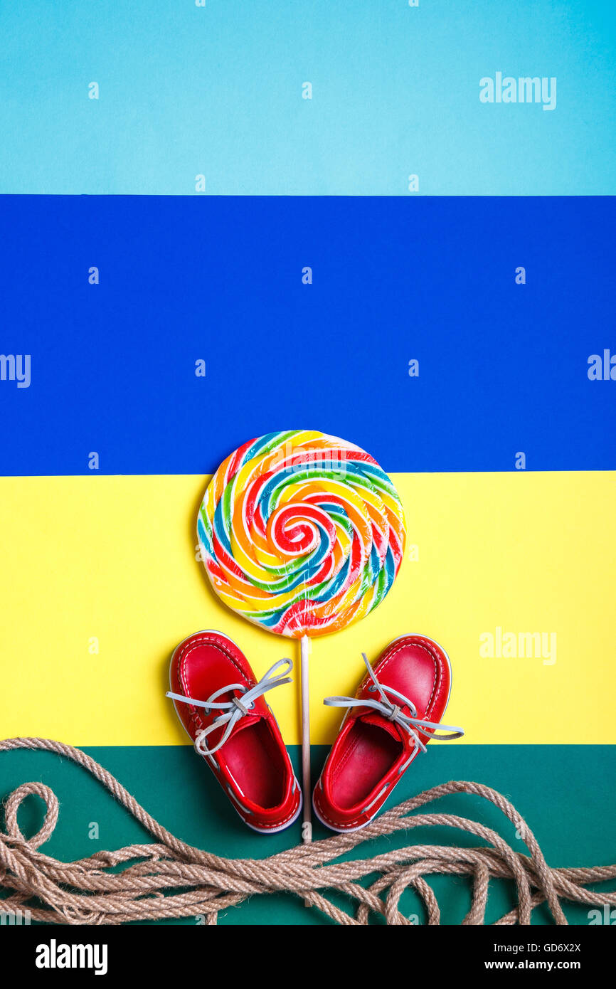 Petit rouge chaussures bateau près de big multi-colored lollipop et corde  sur fond de couleur. Vue d'en haut. L'espace de copie, frame Photo Stock -  Alamy
