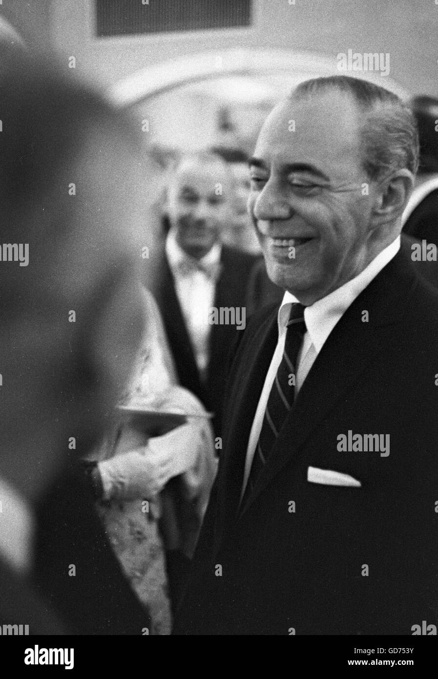 Richard Rodgers parlant avec des invités à un cocktail, 1962. Banque D'Images