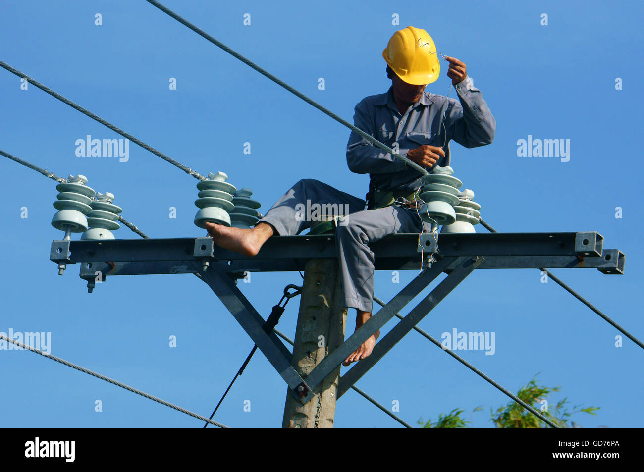 Électricien asiatique Grimpez haut en pôle pour travailler, monteur de réseau par câble, l'homme électrique réparation danger post et dangereux Banque D'Images