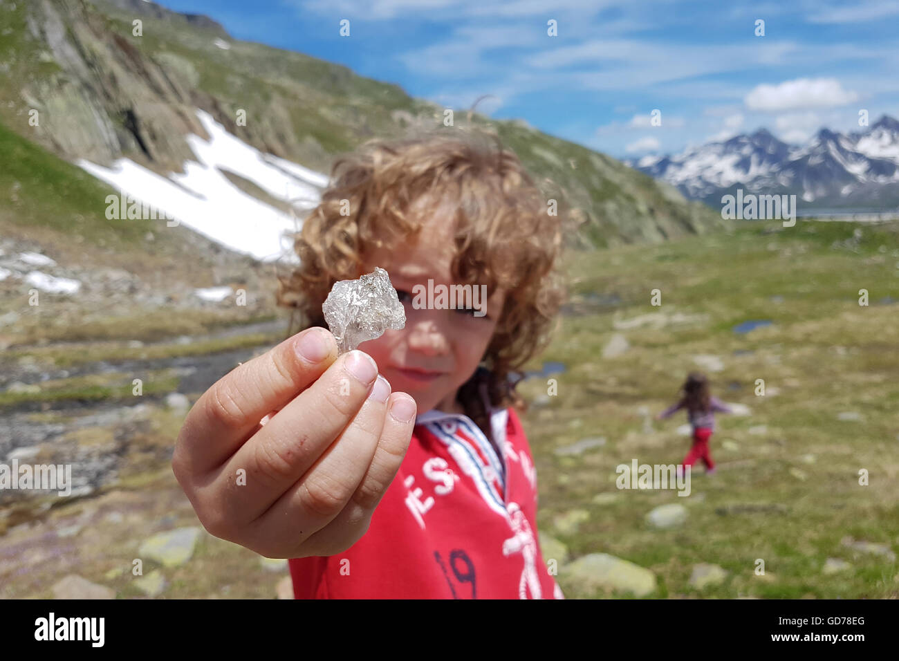 Garçon montre cristal minéraux trouvés dans les Alpes de haute randonnée Banque D'Images